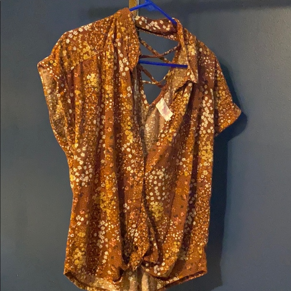 Brown shirt with white/yellow floral design.